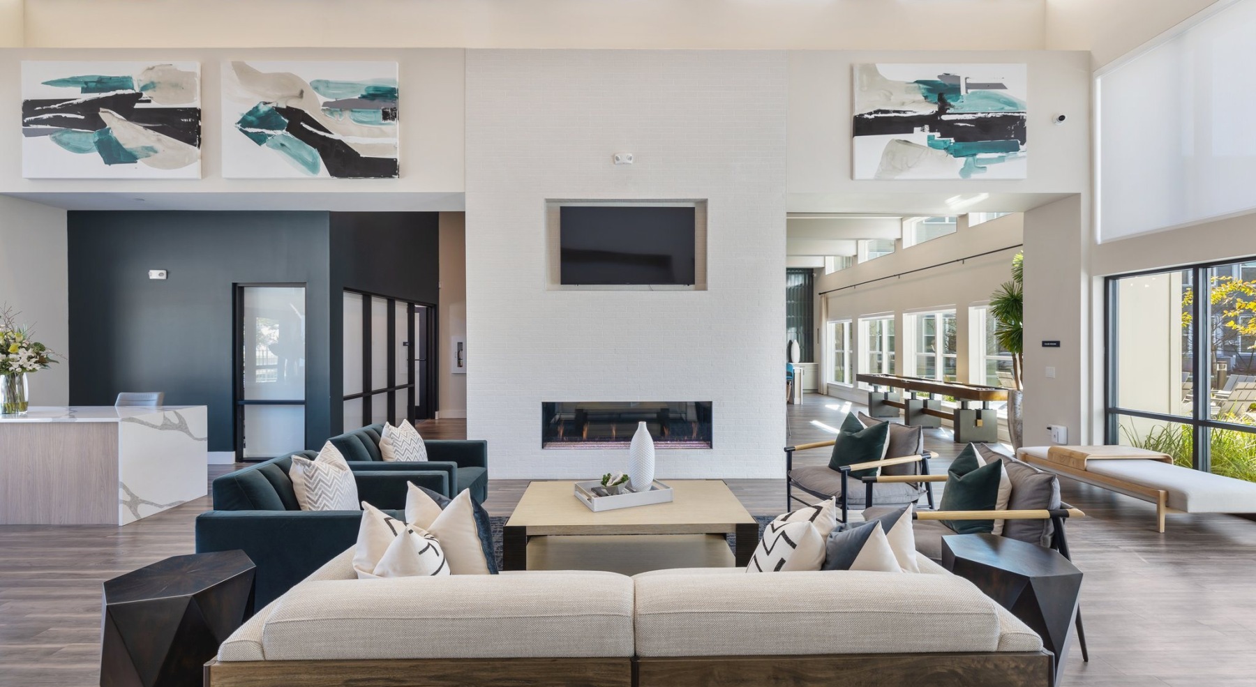 a spacious clubroom with a sofa and a media area