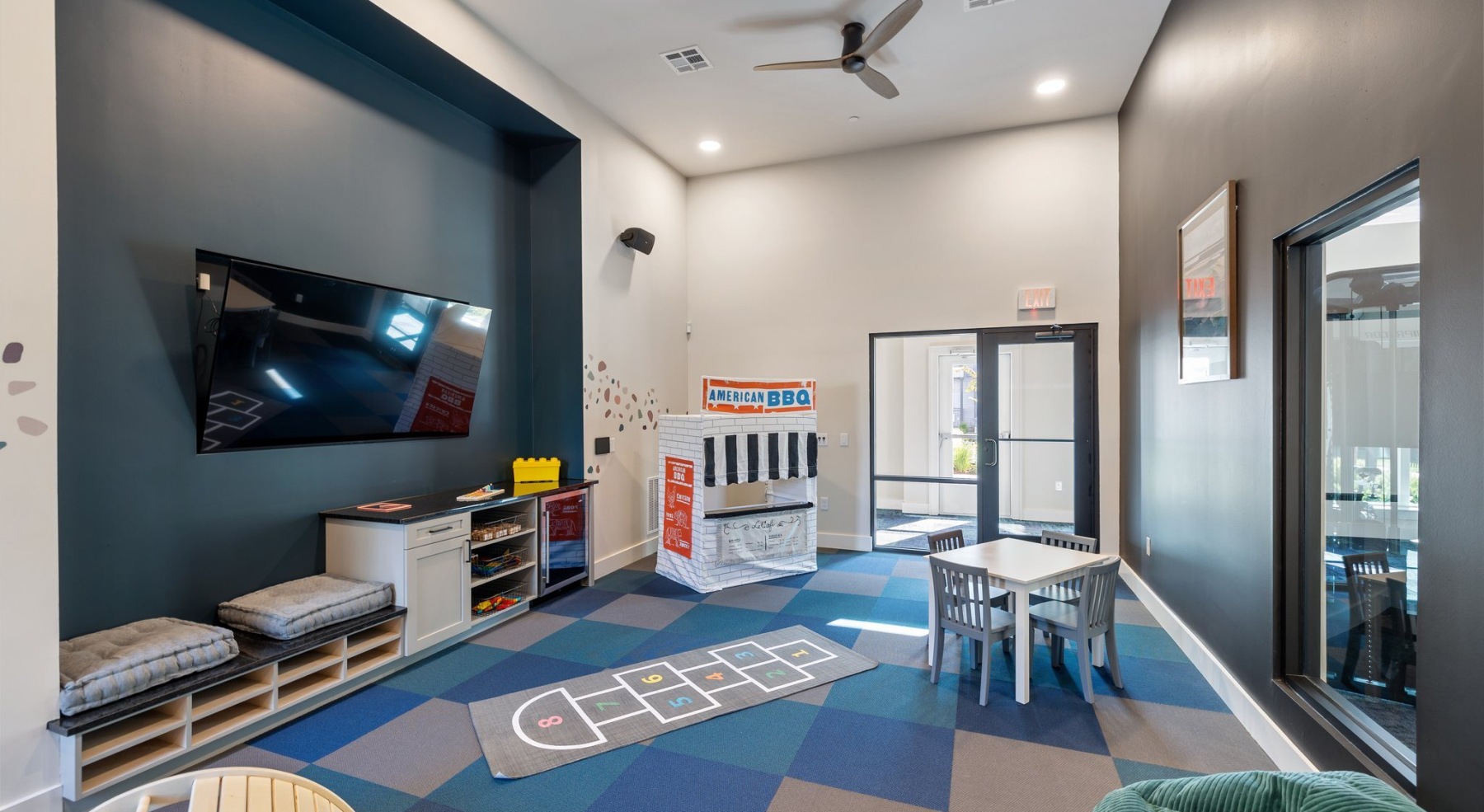 a children's playroom with toys and a media area