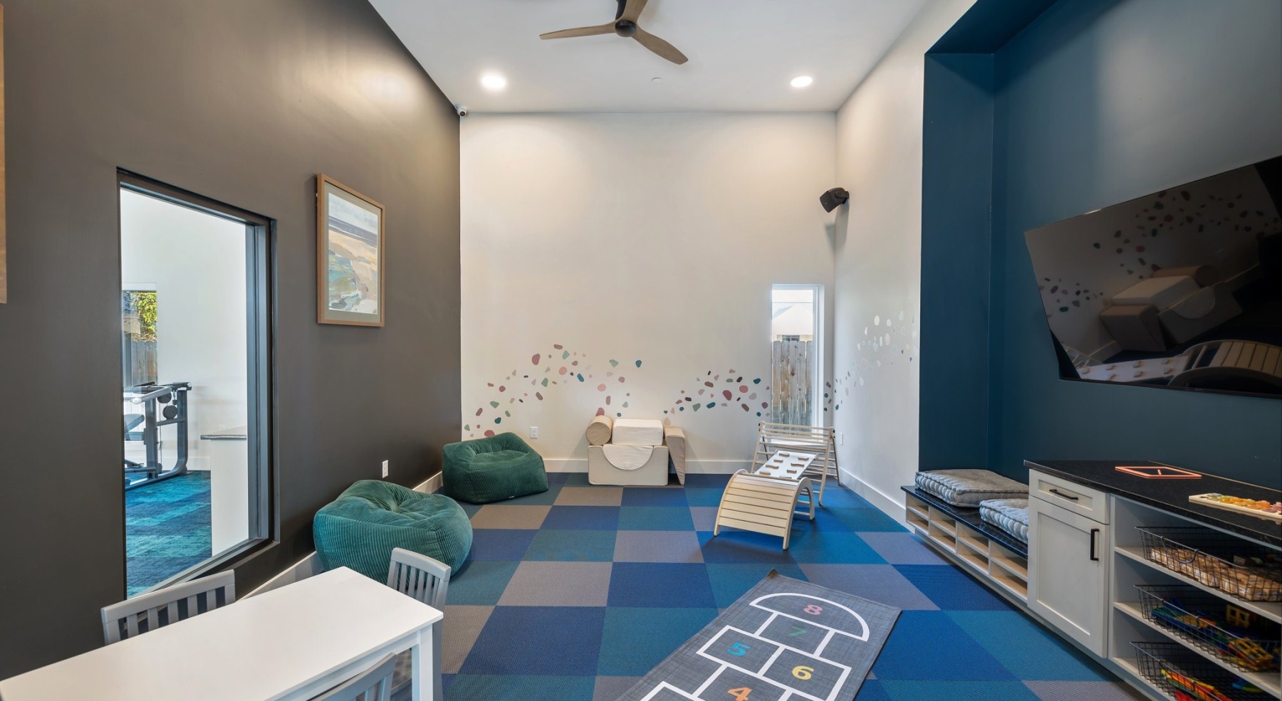 a children's playroom with toys and a media area