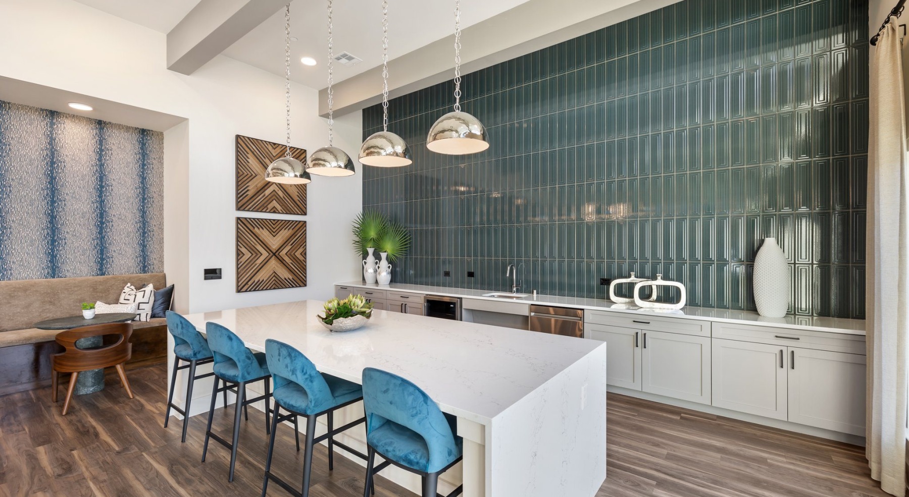 a spacious resident lounge with a large island, pendant lighting, and ample seating