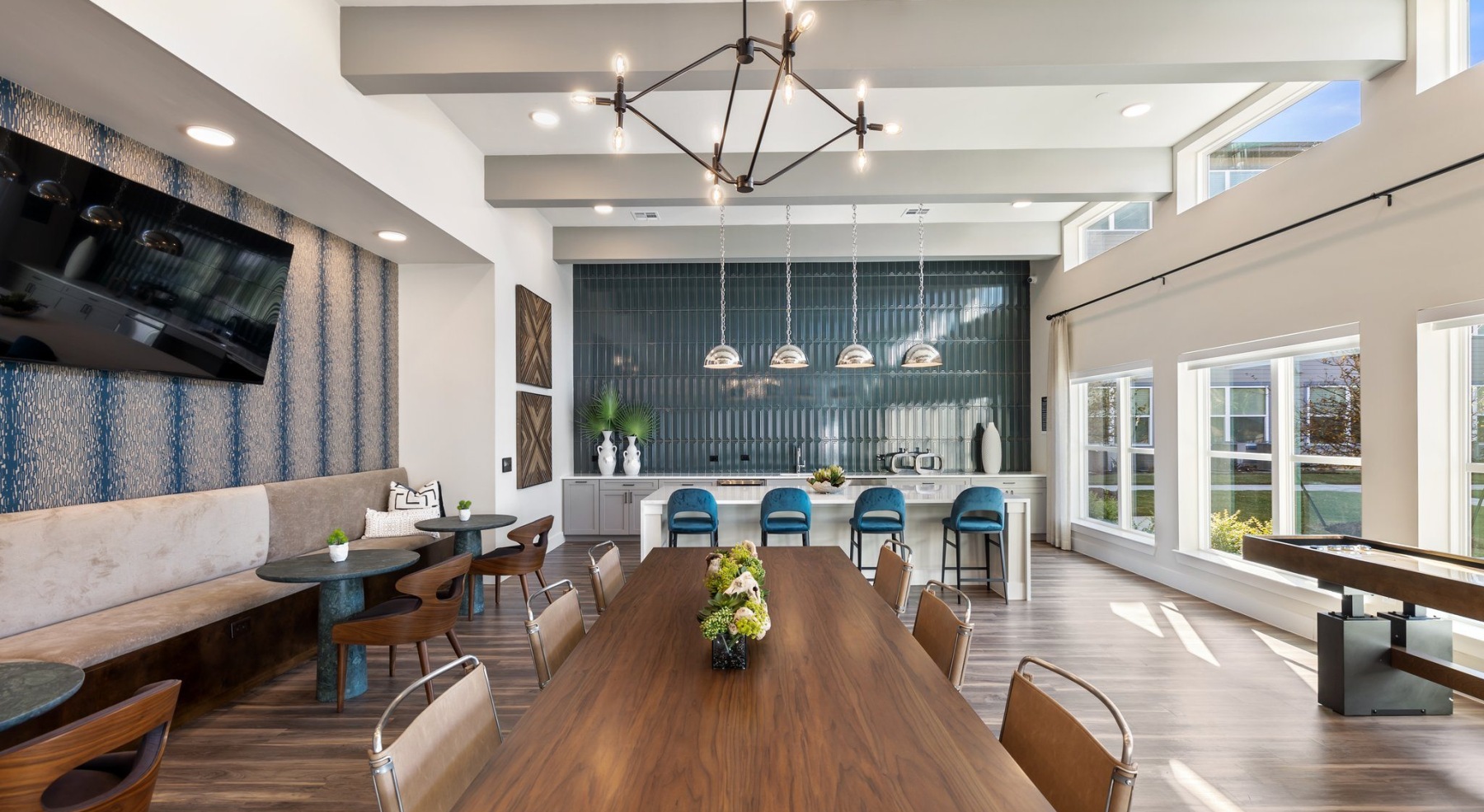 a spacious resident lounge with a large island, pendant lighting, and ample seating